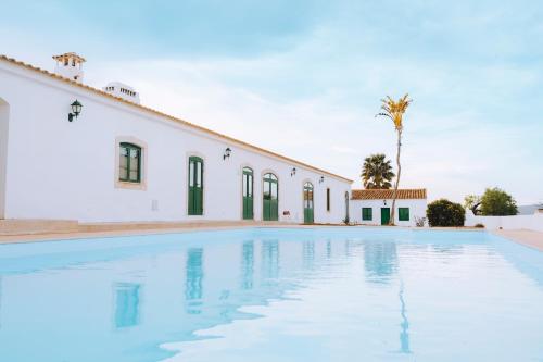阿尔布费拉Cerca Velha - Country House的白色建筑前的游泳池