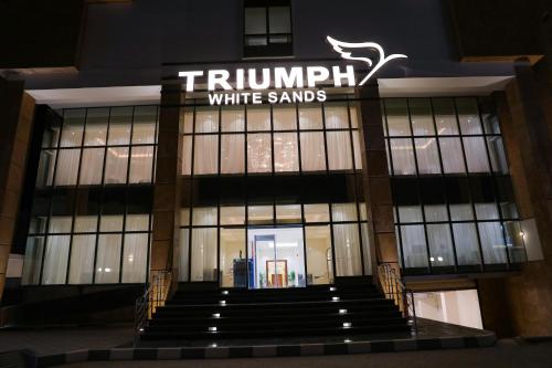 马特鲁港Triumph White Sands Hotel的上面有标志的白沙建筑