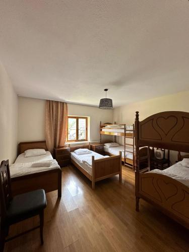 瓦勒博内Hostel Quku i Valbones的一间卧室设有三张双层床和一扇窗户。