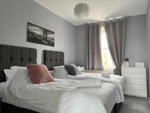 柯科迪Captivating 2-Bed Apartment in Kirkcaldy的一间卧室设有两张床和窗户。