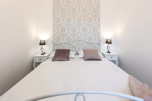 里耶卡APARTMAN BORGO MARINA - by the sea的一间卧室配有一张带两盏灯的大型白色床。