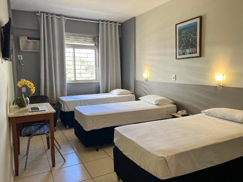 巴西利亚里维埃拉酒店的酒店客房设有三张床和一张桌子