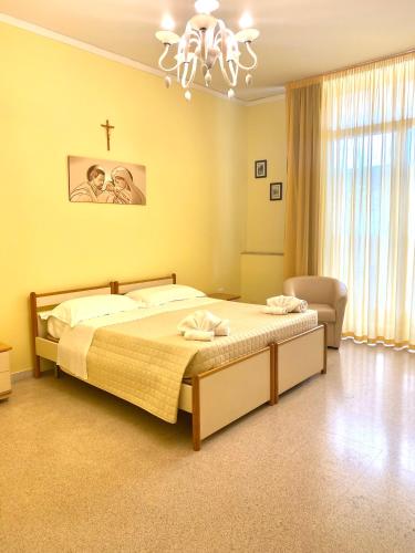 莱切OSTELLO MADRE SANTINA的卧室配有一张床,墙上有十字架