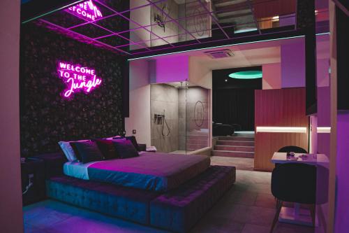 卡索里亚Capri Spa Hotel的卧室配有一张床,墙上挂着 ⁇ 虹灯标志