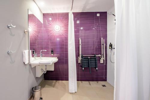 奥伯丁Premier Inn München Airport Ost的紫色浴室设有水槽和淋浴