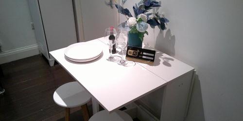 伦敦Stylish West London Getaway Apartment - Shepherd Bush的白色的桌子,花瓶和酒杯