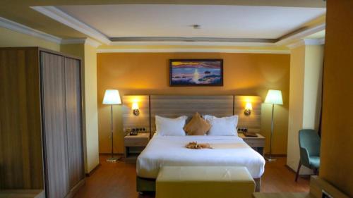 亚的斯亚贝巴Holiday Hotel Addis Ababa的酒店客房设有一张大床和两盏灯。
