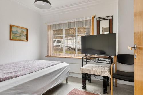 TveitTysso Apartment的一间卧室配有一张床、一张书桌和一个窗户。