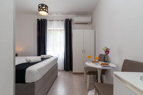特罗吉尔Apartments Bozan的酒店客房配有一张桌子和一张桌子,