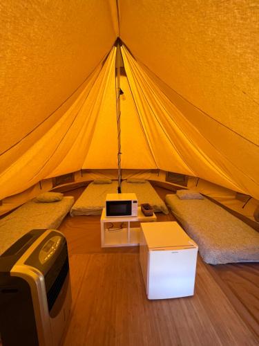 格罗韦Camping & Glamping Muiñeira的帐篷配有一张床和电视