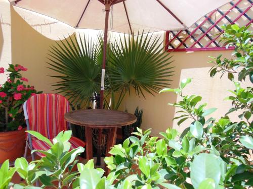 塔韦尔纳斯沙漠花园乡村之家酒店的桌子和两把椅子,放在带植物的伞下