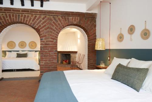墨西哥城AmazINN Places Casa Coyoacan的一间卧室配有一张床和一个砖砌壁炉