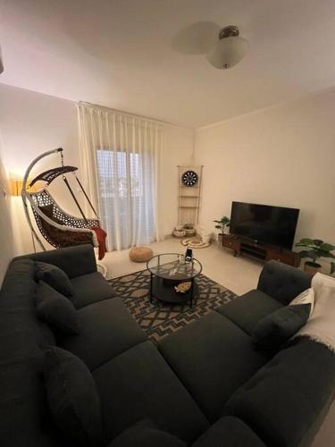 阿卜杜勒国王经济城شقة الاحلام的客厅配有黑色沙发和电视