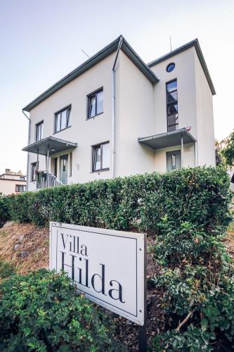 维尔扬迪Hilda Villa的白色房子前面的标志