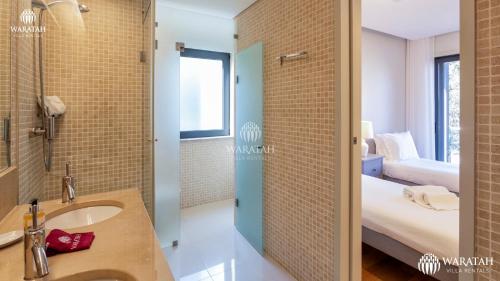韦尔都勒博Apartment Micaela的一间带水槽和淋浴的浴室以及一间卧室