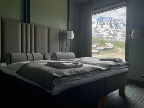 GaustablikkGausta View的一间卧室配有一张床,享有雪覆盖的山脉美景
