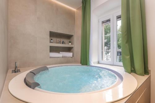 里耶卡Ribica Luxury Rooms的带窗户的浴室内的大蓝色浴缸