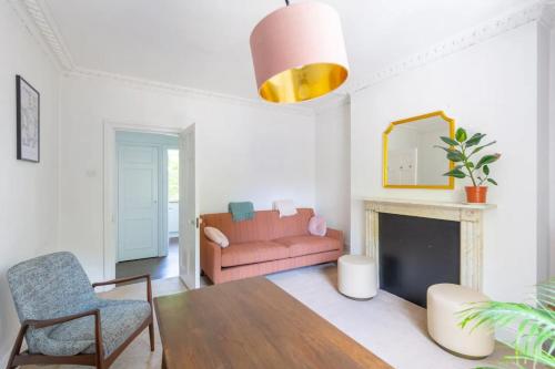 伦敦Charming & Central 2BD Flat - Islington的客厅配有粉红色的沙发和壁炉