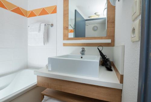 里昂Apparthotel Privilodges Lyon Lumière的浴室配有白色水槽和浴缸。