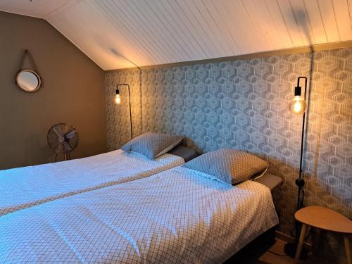 威布林Chez Baf - Wibrin - Houffalize的一间卧室配有两张床,墙上有两盏灯