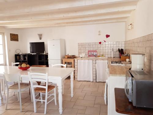 里耶Charming home in Provence - 6 pers.的厨房配有白色的桌子和白色的椅子