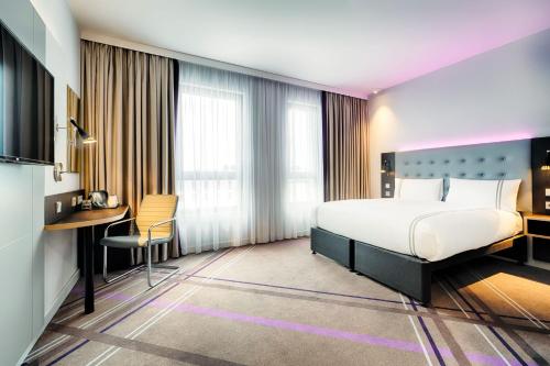 柏林Premier Inn Berlin Airport的配有一张床和一张书桌的酒店客房