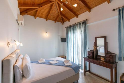 艾拉方索斯Voula Resort的一间卧室配有一张床、镜子和一张桌子