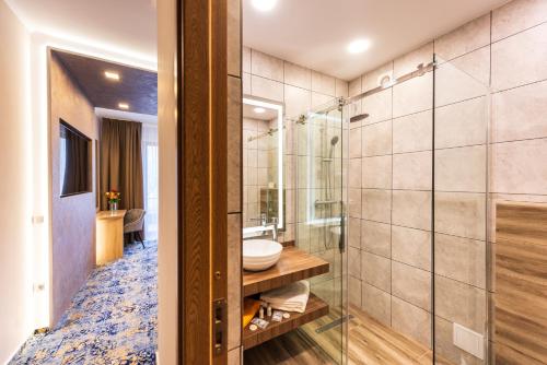 伯伊莱图什纳德Hotel Tusnad的带淋浴和盥洗盆的浴室