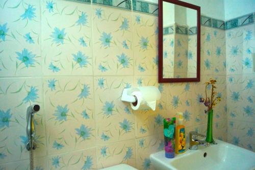 Santa RosaMadie's Place Bed & Breakfast in Santa Rosa, Laguna near Enchanted Kingdom的浴室配有水槽和墙上的蓝色鲜花