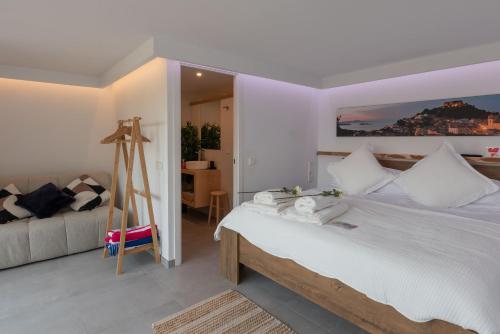 巴古尔Romantic modern apartment private swimming pool 5 min walk from Begur Centre的卧室配有白色的床和沙发