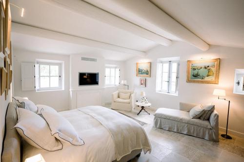 梅内尔伯Le Domaine du Fortin的白色卧室设有一张大床和一张沙发