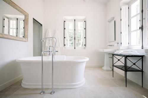 梅内尔伯Le Domaine du Fortin的白色的浴室设有浴缸和两个盥洗盆