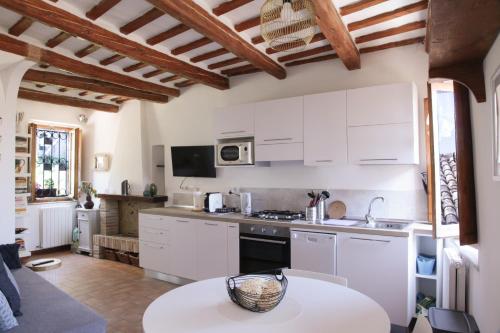 马切拉塔CIRIBACCO ROOMS的厨房配有白色橱柜和桌子