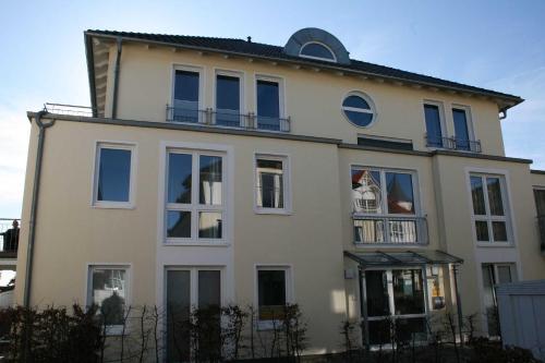 奥斯赛拜-塞林Haus Möwe II - Ferienwohnung 10的白色的房子设有蓝色的窗户和阳台