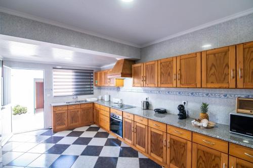 波瓦桑Casa Xadrez的厨房设有木制橱柜和 ⁇ 格地板。