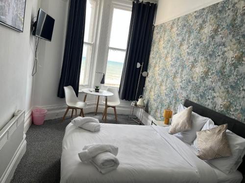 伊斯特布恩OYO Marine Parade Hotel, Eastbourne Pier的一间卧室配有带毛巾的床