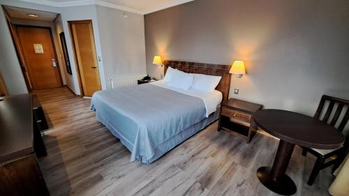 科伊艾科迭戈德阿尔马格罗科伊艾克酒店的配有一张床、一张桌子和一张桌子的酒店客房