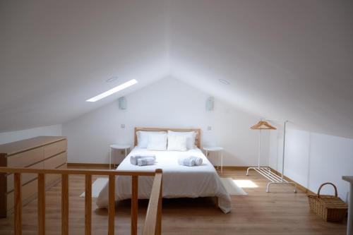 CapinhaCasa da Rabita的卧室配有白色的床,铺有木地板