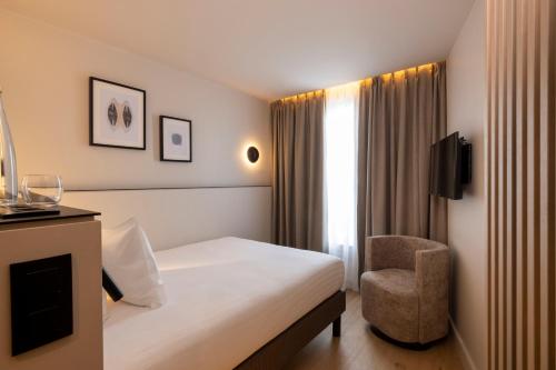 巴黎Hôtel Esté的配有一张床和一把椅子的酒店客房