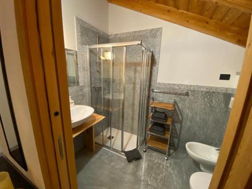 平佐洛B&B Casa il sasso的浴室设有玻璃淋浴间和2个水槽。