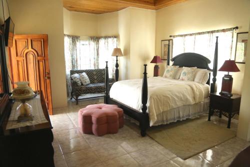 尼格瑞尔Jannetta's @Whimhill Bed & Breakfast的一间卧室配有一张大床和一把椅子