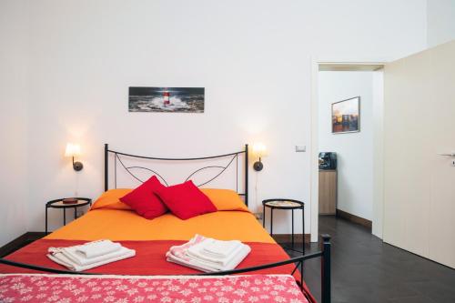 卡塔尼亚Antico Borgo的一间卧室配有橙色床和红色枕头