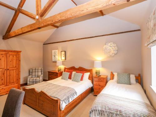 诺里奇Shorthorn Barn的卧室设有2张床和木梁。