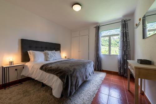 圣维森特Pereira Place - Cottage的一间卧室设有一张大床和一个窗户。