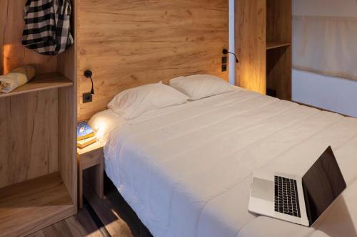 纳扎雷Ohai Nazaré Outdoor Resort的一间卧室配有一张带笔记本电脑的床