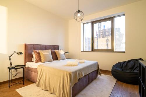 贝尔格莱德Belgrade Waterfront - River Residence的一间卧室设有一张大床和一个窗户。
