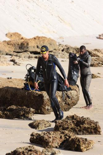 达赫拉DAKHLA DIVING CAMP的两名穿着湿衣的男子在海滩上散步