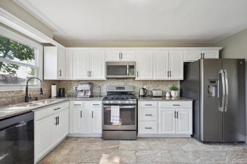 格伦维尤Charming Contemporary Family Home home的厨房配有白色橱柜和不锈钢用具