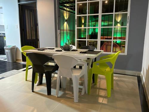布加CASA10 DIEZ En TODO !的一间带桌子和绿色椅子的用餐室
