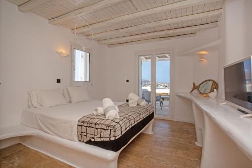 米克诺斯城Nuera Villa的一间白色卧室,配有床和电视